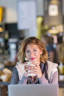 Mixed race teenage girl drinking cup of coffee