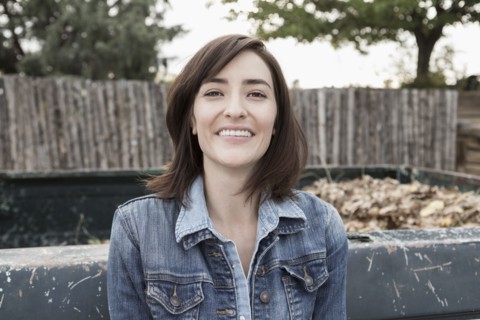 Hispanic woman smiling at truck