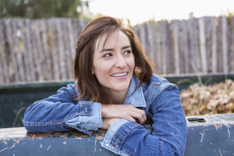 Hispanic woman sitting in truck bed
