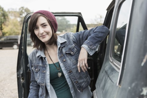 Hispanic woman standing at truck