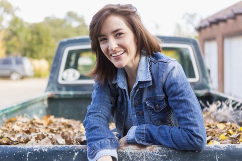 Hispanic woman sitting in truck bed