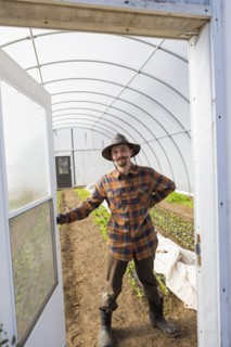 Caucasian farmer opening greenhouse door