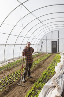 Caucasian farmer standing in greenhouse