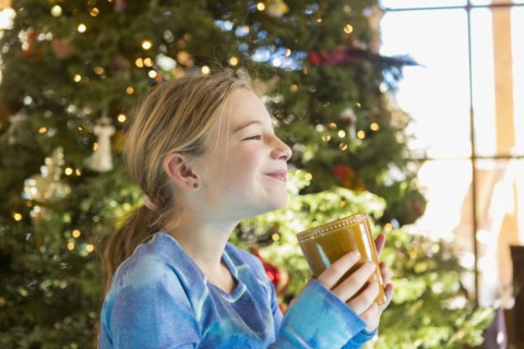 Caucasian girl drinking hot cocoa at Christmas