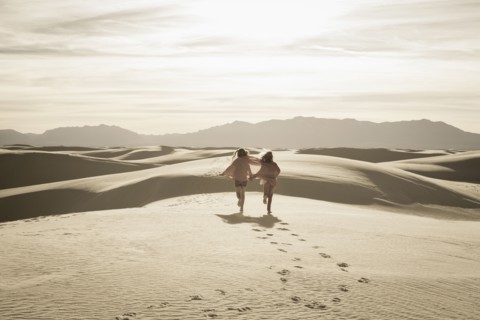 Caucasian children running in desert