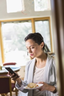 Businesswoman using cell phone and headset in office