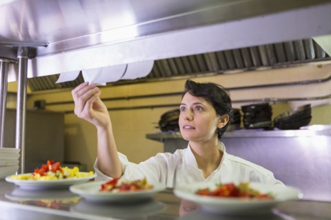 Caucasian chef reading orders in restaurant kitchen