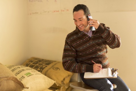 Hispanic entrepreneur talking on telephone in store