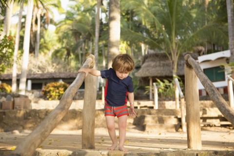 Caucasian boy holding staircase banister