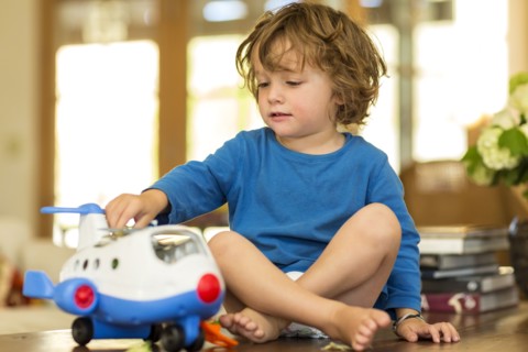 Caucasian boy playing with toy airplane on floor