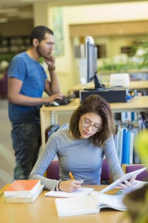 Mixed Race boy and girl studying in library