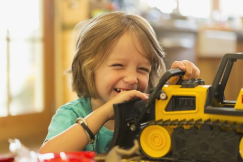 Portrait of Caucasian boy playing with toy bulldozer