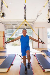 Mixed Race man using resistance bands in gymnasium