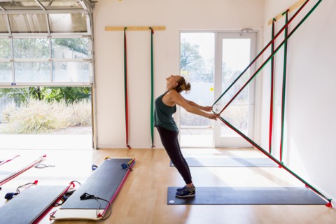 Caucasian woman using resistance bands in gymnasium