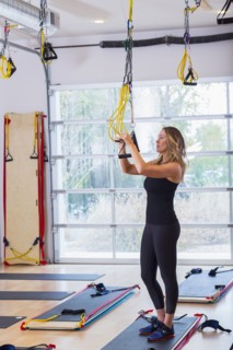 Caucasian woman adjusting resistance bands in gymnasium