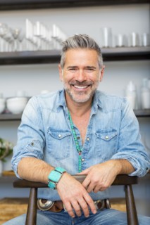 Smiling Caucasian man leaning on chair in store