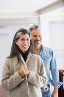 Man watching woman examining coat in store