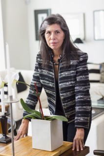 Serious Hispanic woman leaning over orchid