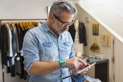 Caucasian man using digital tablet in store