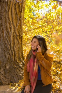Asian woman talking on cell phone in autumn