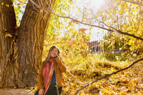 Asian woman talking on cell phone in autumn