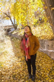 Smiling Asian woman smelling fresh air in autumn