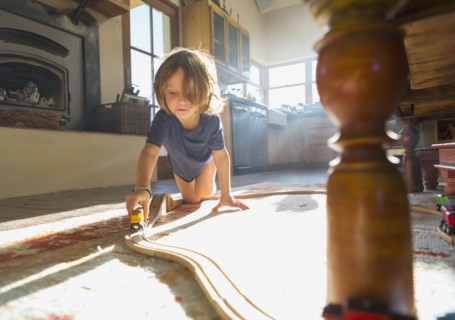 Caucasian boy playing with toy race track on floor