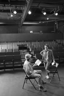 Caucasian actors rehearsing with scripts in theater