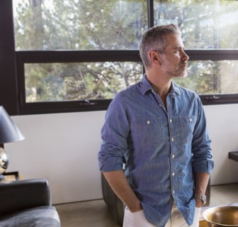 Portrait of pensive Caucasian man in livingroom