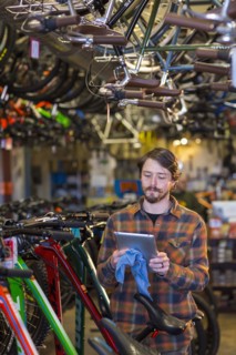 Caucasian worker using digital tablet in bicycle shop