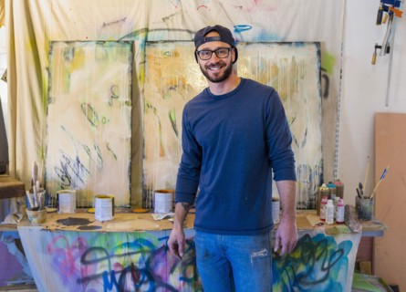 Portrait of Caucasian man standing near paintings