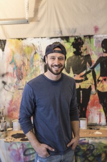 Portrait of Caucasian man standing near paintings