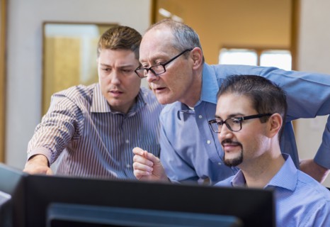 Businessmen talking in office near computer