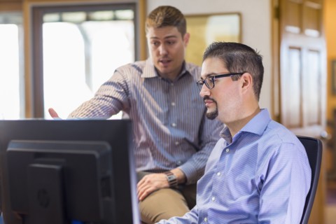 Businessmen talking near computer in office