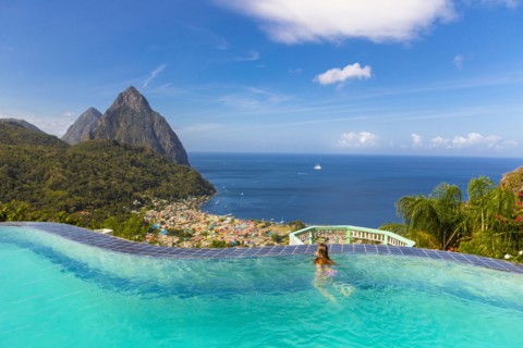 Caucasian girl swimming in infinity pool