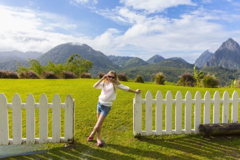 Caucasian girl wearing sunglasses leaning on fence