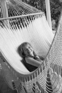 Smiling Caucasian girl laying in hammock
