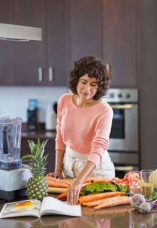 Hispanic woman reading cookbook