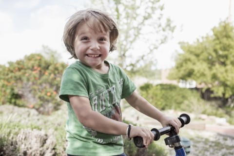 Portrait of excited Caucasian boy holding handlebars