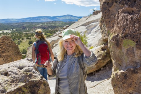 Caucasian grandmother hiking with granddaughter near rocks