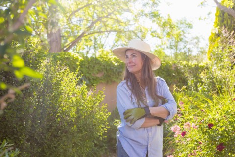 Older Caucasian woman admiring flowers in garden