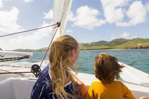 Wind blowing hair of Caucasian brother and sister in sailboat