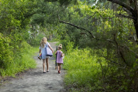 Caucasian sisters walking on dirt path