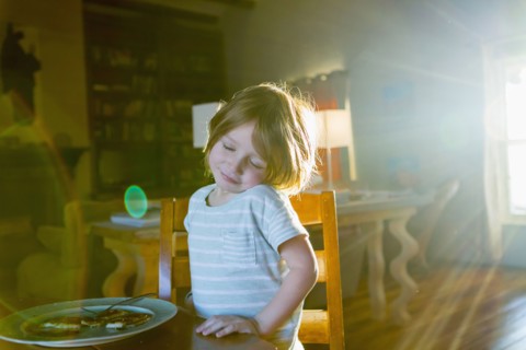 Sunshine on Caucasian boy eating food at table