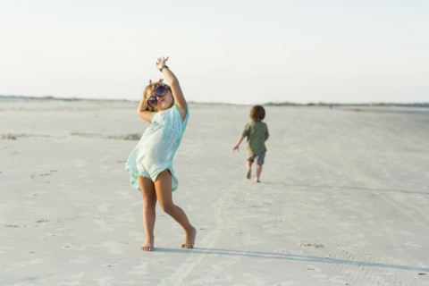 Caucasian girl posing with sunglasses on beach