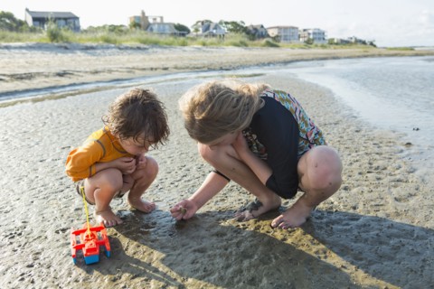 Caucasian brother and sister searching on beach