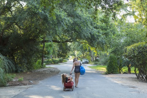 Caucasian mother pulling son and daughter in wagon