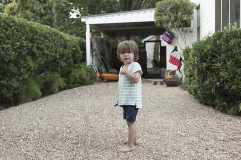 Portrait of curious Caucasian boy standing in driveway