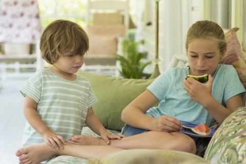 Caucasian brother and sister watching digital tablet on sofa