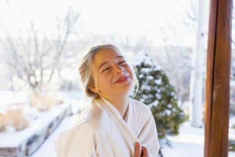 Caucasian girl wearing bathrobe laughing